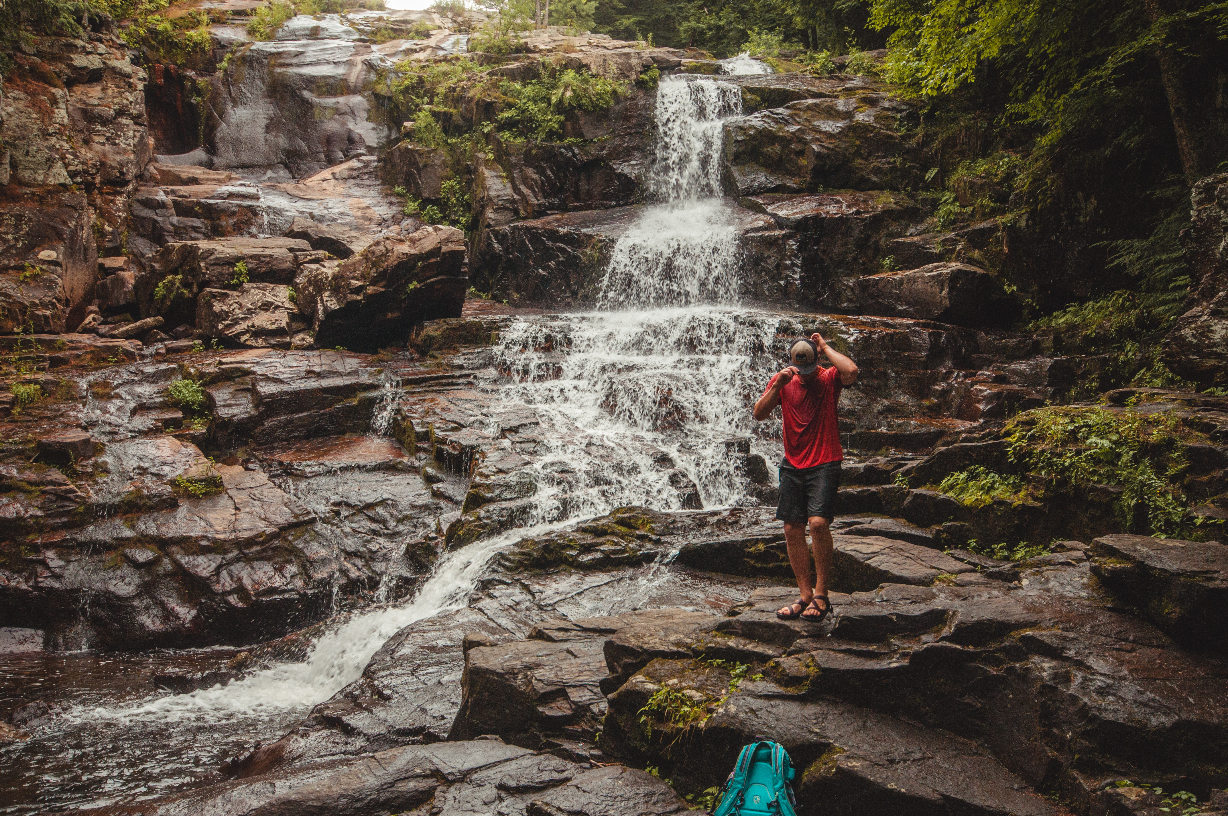 Hiker by a waterfall in the adirondack park 