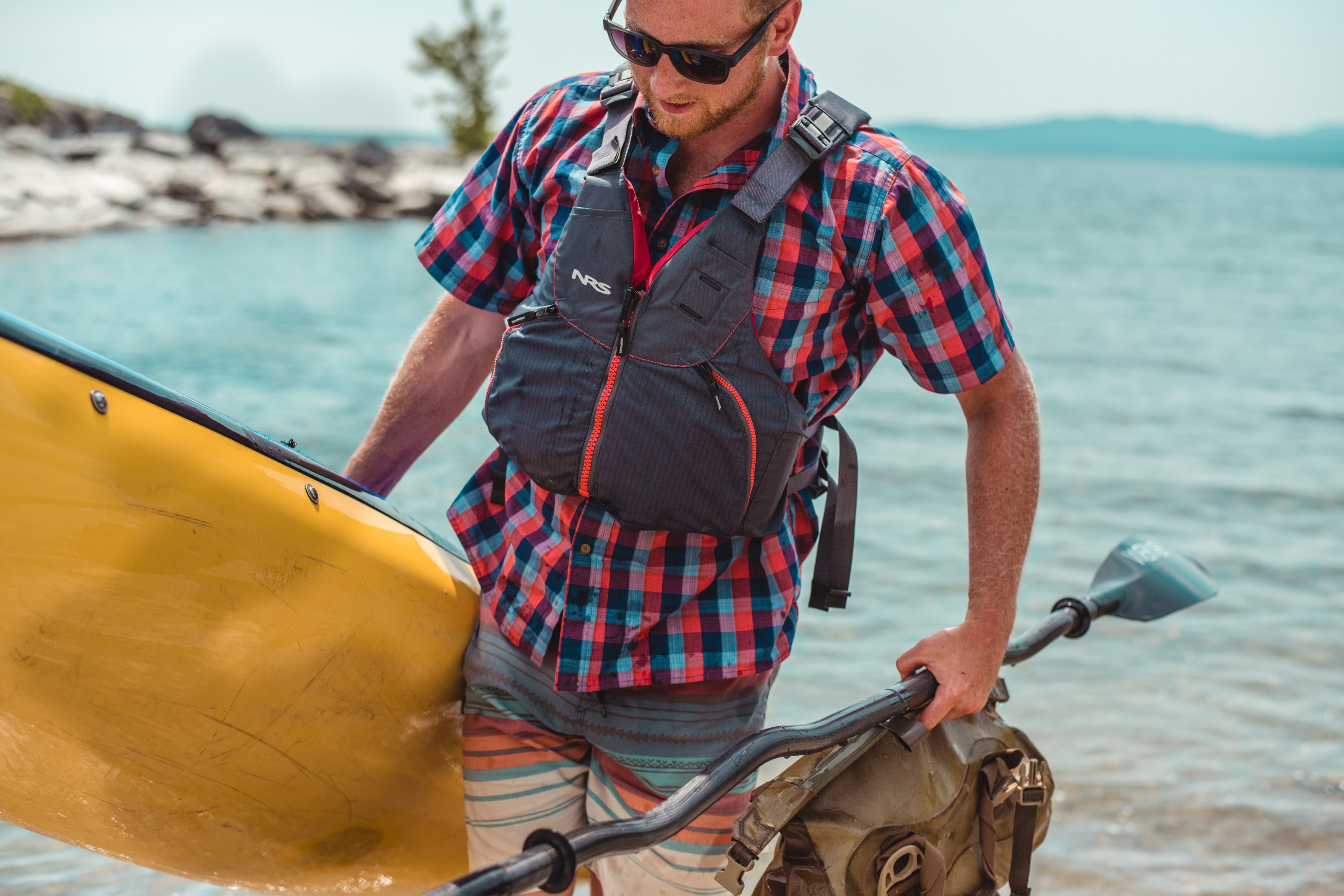 man carrying safe paddling gear and kayak