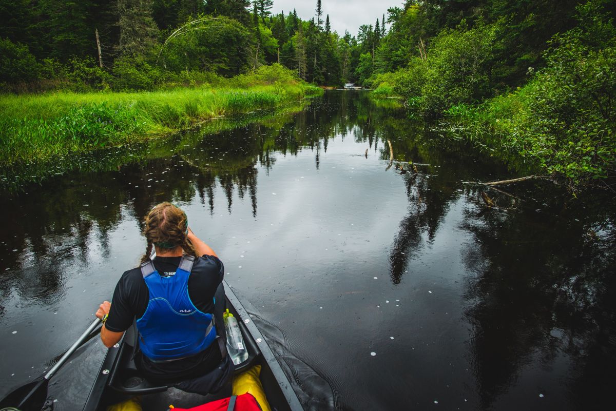 woman enjoying the benefits of paddling through the Marion River in the Adirondacks