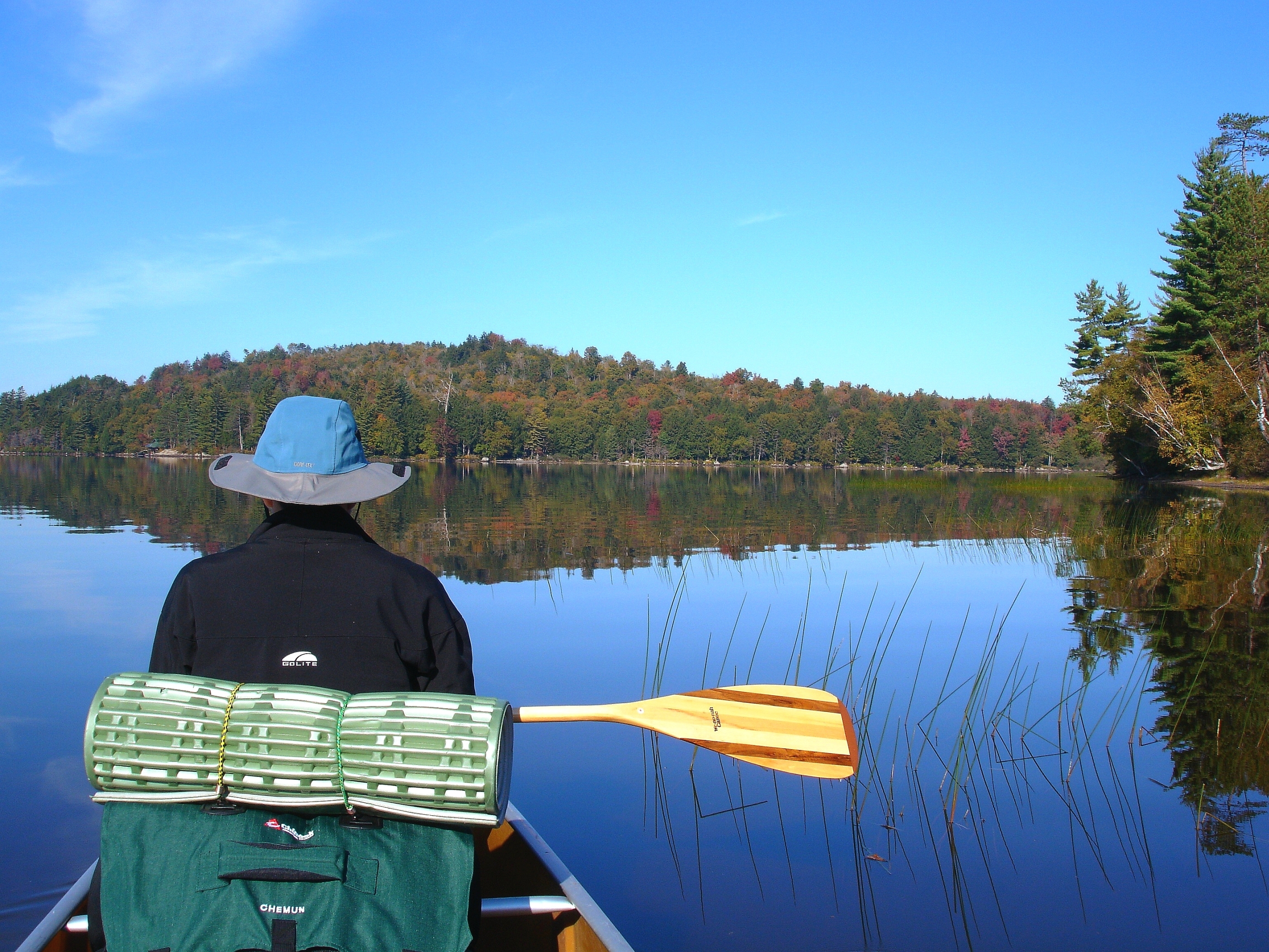 man enjoying the benefits of paddling a canoe on Tupper Lake