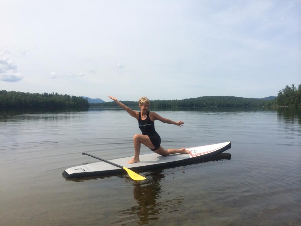 woman doing yoga on a stand up paddle board in the Adirondacks