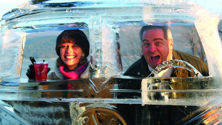 two people posed with a Lake George ice bar ice sculpture