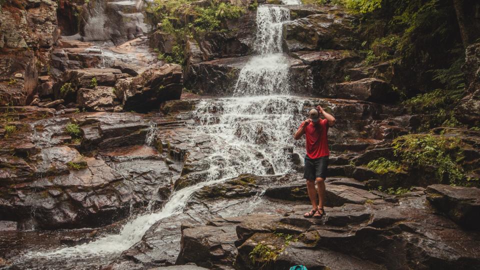 man standing near an Adirondack waterfall