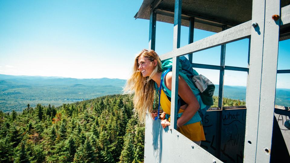 female hiker inside Adirondack fire tower during a hike