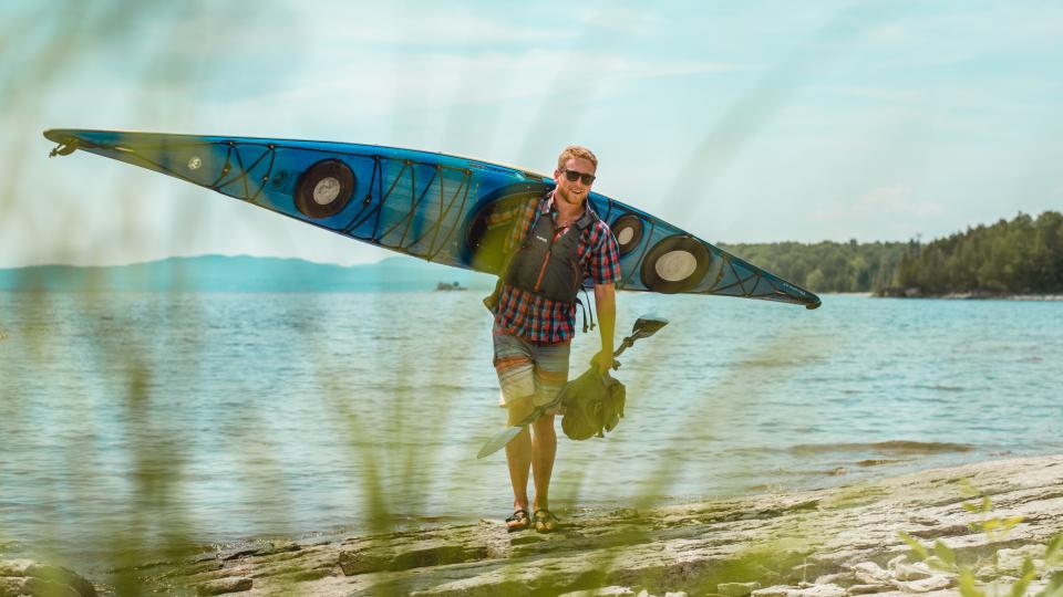 man carrying a kayak