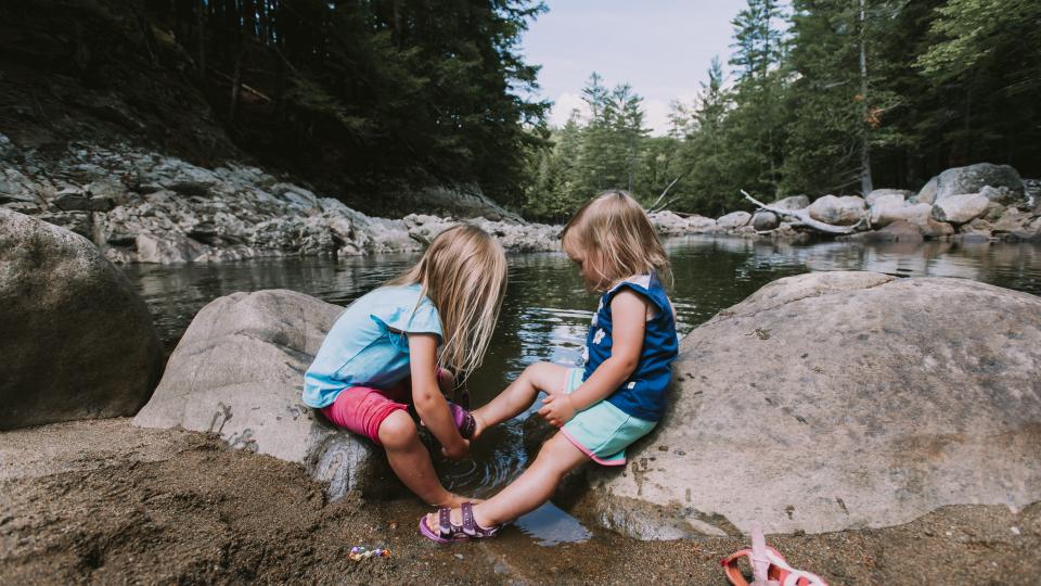 two sisters enjoying a break during a family hike in the Adirondacks