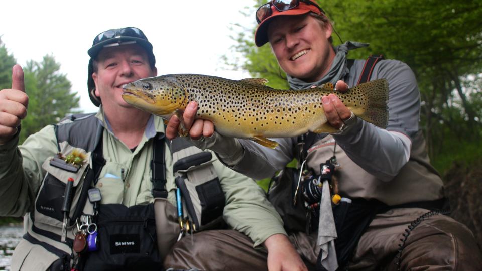 man holding up fish caught in the Adirondacks