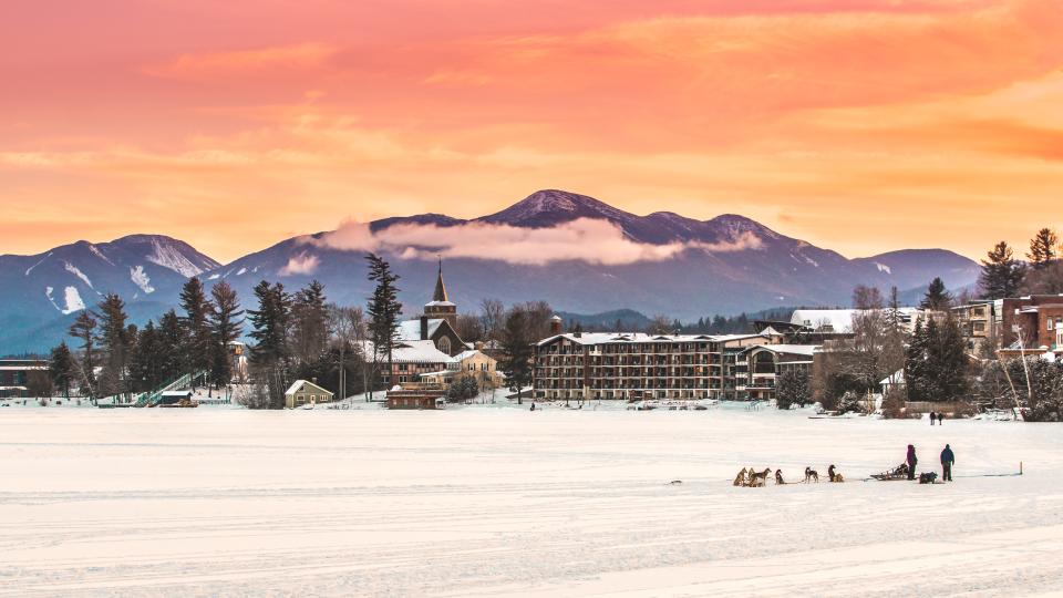 dogsled gliding across Mirror Lake in the Adirondacks in the winter