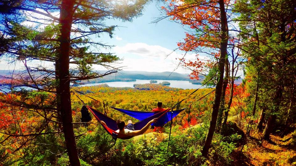Two people in hammocks over looking high peaks 